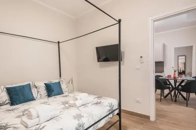 a white bedroom with a bed with a black frame at C2 Top Class Apartment, 2 camere da letto con giardino in zona Via Veneto distante 15 minuti a piedi da Fontana di Trevi in Rome