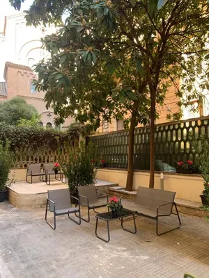 a patio with chairs and tables and a fence at C2 Top Class Apartment, 2 camere da letto con giardino in zona Via Veneto distante 15 minuti a piedi da Fontana di Trevi in Rome