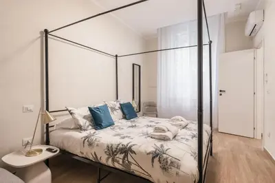 a bedroom with a canopy bed with blue pillows at C2 Top Class Apartment, 2 camere da letto con giardino in zona Via Veneto distante 15 minuti a piedi da Fontana di Trevi in Rome