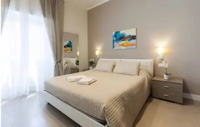 a bedroom with a large bed and a window at Maison Romana in Rome