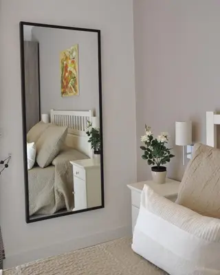 a mirror in a room with a bed and a chair at Maison Romana in Rome