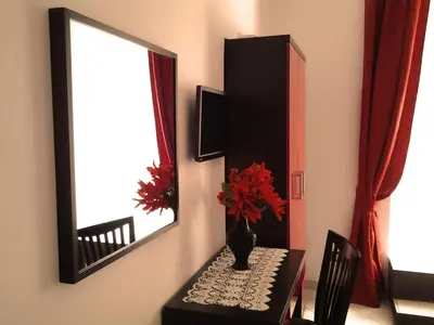 a table with a mirror and a vase on it at Termini in Bed in Rome