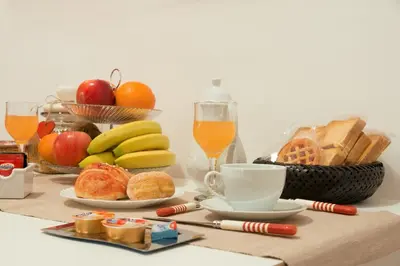a table with a breakfast of fruit and bread and orange juice at Termini in Bed in Rome