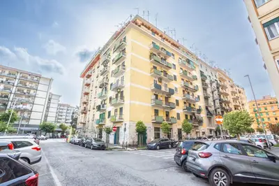 a yellow building with cars parked in a parking lot at Espress break in Rome