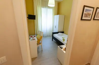 a small room with a bed and a room with a table at Magna Cura in Rome