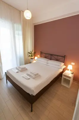a bedroom with a large white bed with two lamps at Magna Cura in Rome