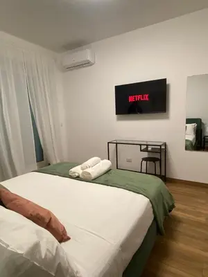 a bedroom with two beds and a tv on the wall at A casa di nonna Lina - Apartment in Ostiense in Rome