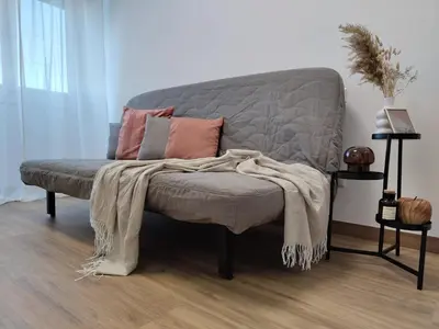 a gray couch with pillows on it in a room at A casa di nonna Lina - Apartment in Ostiense in Rome