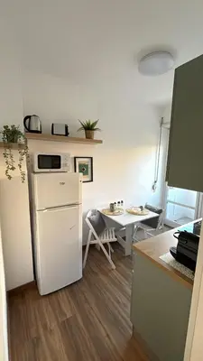 a kitchen with a white refrigerator and a table at A casa di nonna Lina - Apartment in Ostiense in Rome