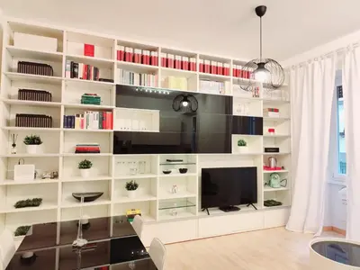 a living room with a large white book shelf at Lovely Flat Roma Università in Rome