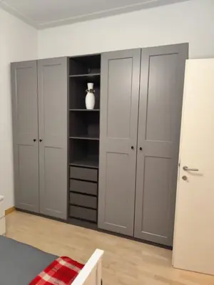 a bedroom with three closets and a white refrigerator at Lovely Flat Roma Università in Rome