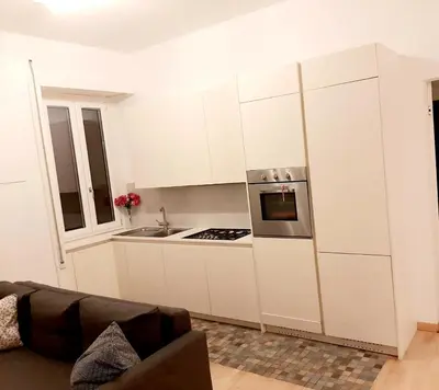 a kitchen with white cabinets and a stove top oven at Lovely Flat Roma Università in Rome