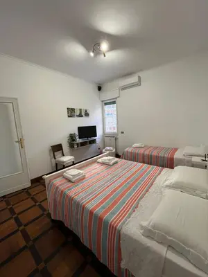 a bedroom with two beds and a television in it at HOUSE BOCCEA Rome in Rome