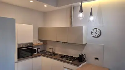 a kitchen with a stove and a clock on the wall at Casa Gabri in Rome