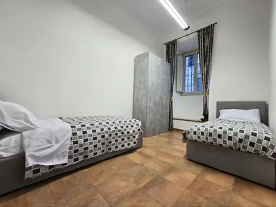 a bedroom with two beds and a window at Comfort House Coppedé in Rome