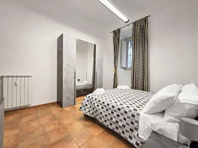 a bedroom with a bed with a black and white checkered blanket at Comfort House Coppedé in Rome