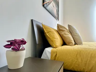 a bedroom with a bed and a vase with a flower on a table at Sergio I Apartment in Rome