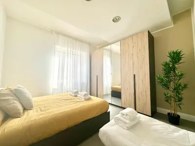 a bedroom with two beds and a mirror at Sergio I Apartment in Rome