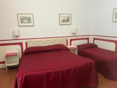 a bedroom with two beds with red sheets at Startermini in Rome