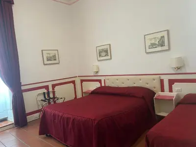 a hotel room with two beds with red sheets at Startermini in Rome
