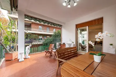 a patio with a wooden table and chairs on a deck at ROMA 1 - Elegante Appartamento con Terrazzo in Rome