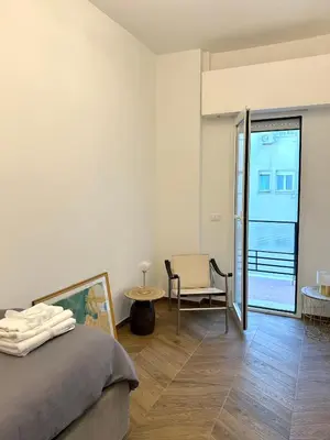 a bedroom with a bed and a table and a chair at Maison Fortuna in Rome