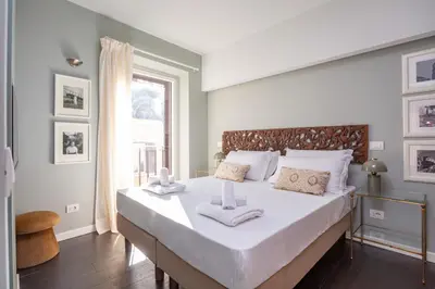 a bedroom with a bed with white sheets and a window at Chic Spanish Steps Retreat in Rome