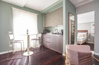 a kitchen with green walls and a table and chairs at Chic Spanish Steps Retreat in Rome