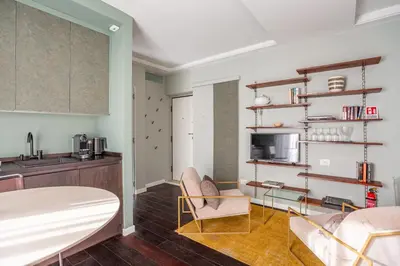 a living room with two chairs and a kitchen at Chic Spanish Steps Retreat in Rome