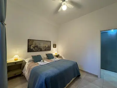 a bedroom with a bed and a ceiling fan at Warm Hideaway in Vibrant Tuscolano in Rome