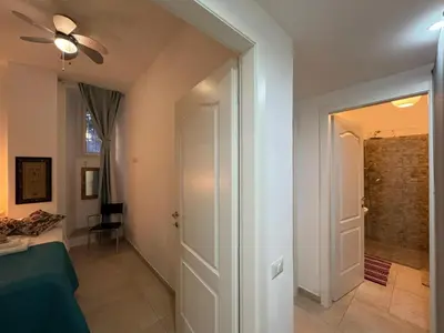 a bedroom with a ceiling fan and a door to a hallway at Warm Hideaway in Vibrant Tuscolano in Rome