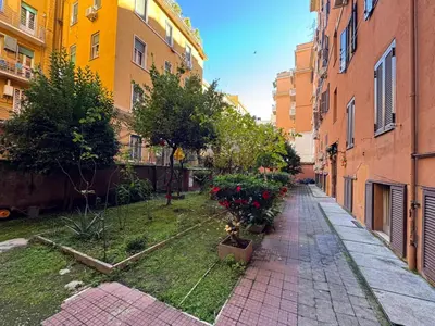 an empty alley with flowers and buildings in a city at Warm Hideaway in Vibrant Tuscolano in Rome
