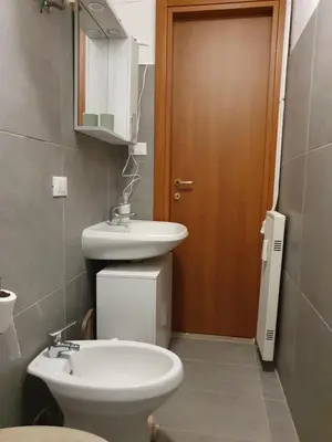 a bathroom with a toilet and a sink and a door at Tom 38 in Rome
