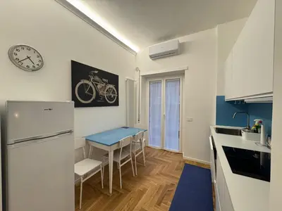 a kitchen with a table and a clock on the wall at Little Diamond in Gianicolense in Rome