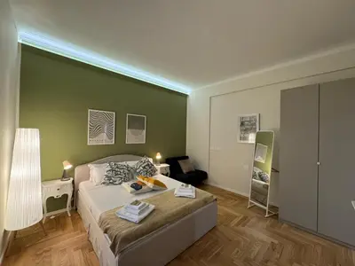 a bedroom with a bed and a green wall at Little Diamond in Gianicolense in Rome