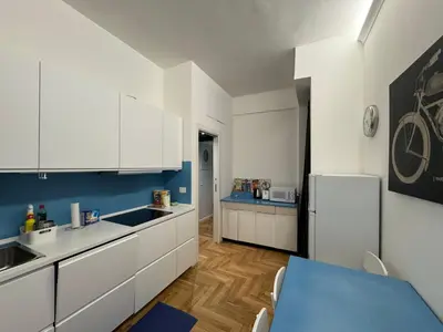 a kitchen with white cabinets and a blue table at Little Diamond in Gianicolense in Rome