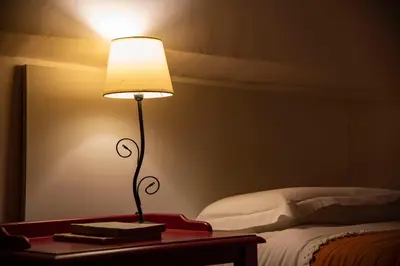a lamp on a table next to a bed at Fissa Dimora in Rome