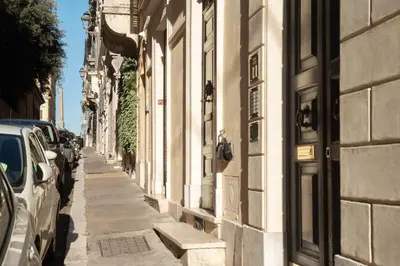 a street with cars parked on the side of a building at The Mirror Suite next to Spanish Steps in Rome