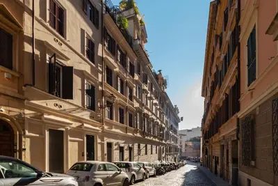 a row of cars parked on a street next to buildings at The Mirror Suite next to Spanish Steps in Rome