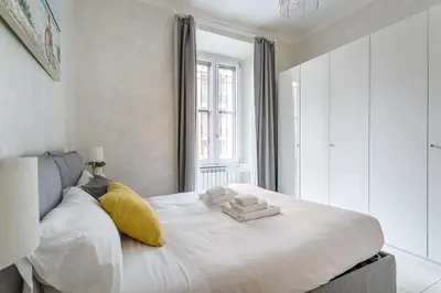 a bedroom with a large white bed with yellow pillows at Iflat Cozy Flat at two steps from Vatican in Rome
