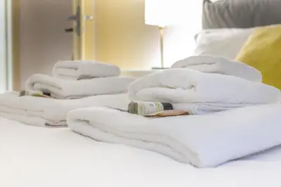 a group of white towels on a bed at Iflat Cozy Flat at two steps from Vatican in Rome