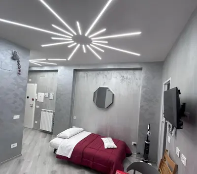 a bedroom with a bed with a red comforter at Breath of Rome 5 min a piedi metro B San paolo poche fermate dal centro di Roma in Rome
