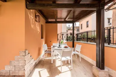 a patio with a table and chairs on a balcony at The Best Rent - Peaceful oasis with garden near the Colosseum in Rome