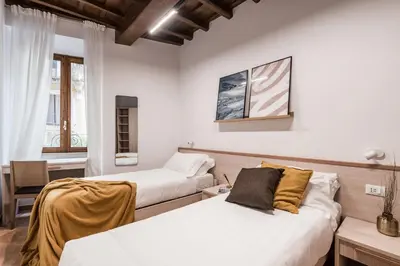 a bedroom with two beds and a desk and a window at The Best Rent - Peaceful oasis with garden near the Colosseum in Rome