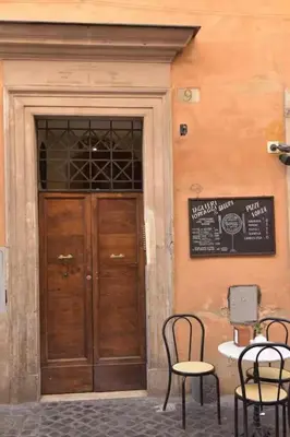 a building with two chairs and a wooden door at Luxury Trevi in Rome