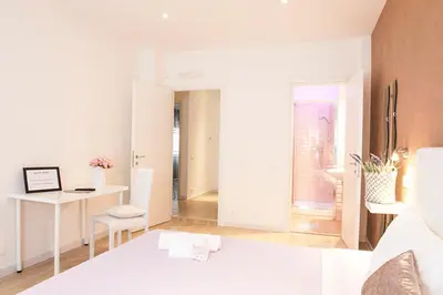 a white room with a bed and a desk and a window at Domus Casaletto in Rome