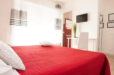 a bedroom with a red bed with a red blanket at Domus Casaletto in Rome