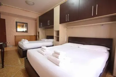 a hotel room with two beds with white sheets at Er Pirata in Rome