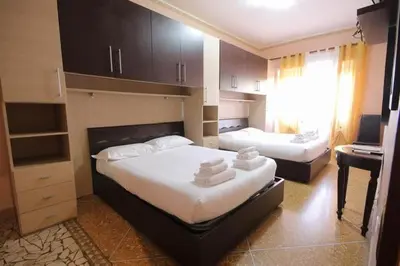 a bedroom with two beds and a desk and a window at Er Pirata in Rome