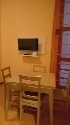 a table and chairs with a television on the wall at Casa Gemelli Gemelli in Rome
